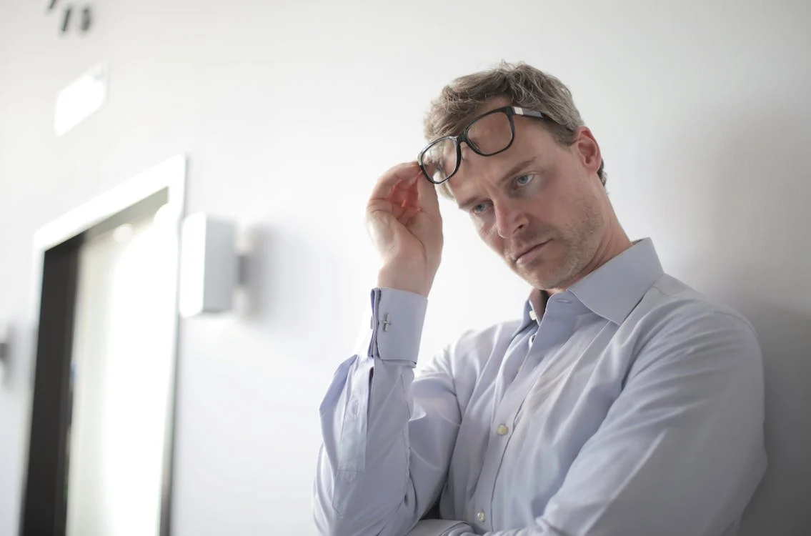 A stressed man leaning on the wall 